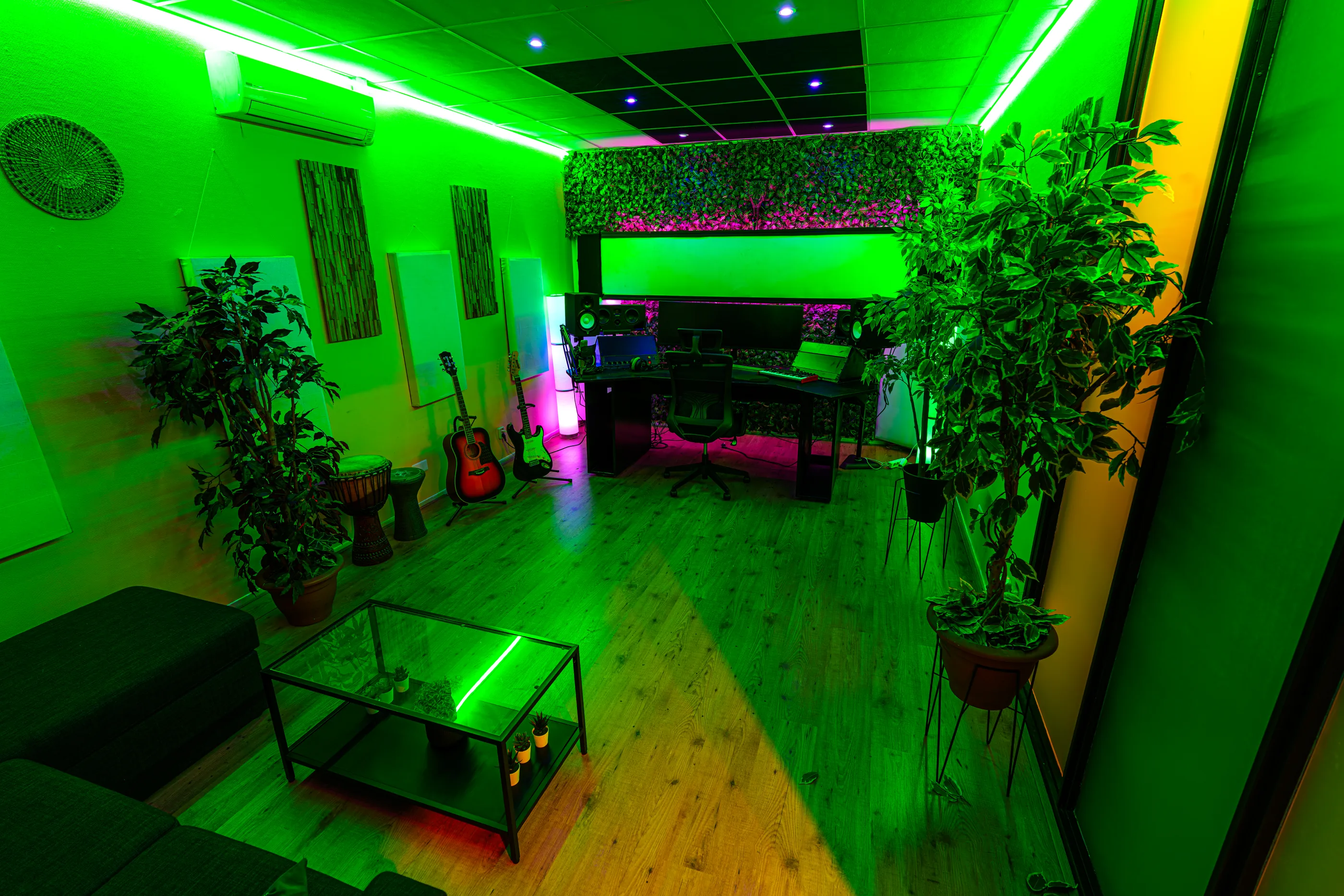 Studio 2 met werkplek, monitoren en gitaren in groen sfeerlicht
